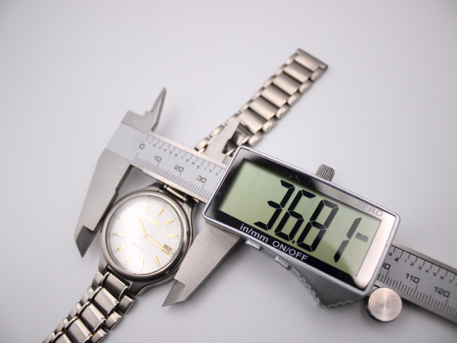 Digital caliper measuring the case diameter of the Seiko watch, showing 36.81mm.