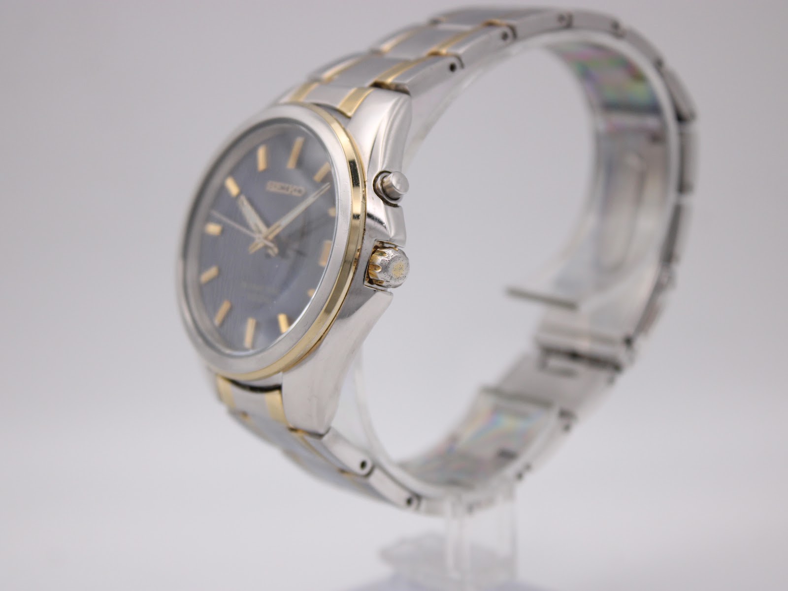 Angled side view of the Seiko Kinetic watch on a stand, highlighting the two-tone case and bracelet.