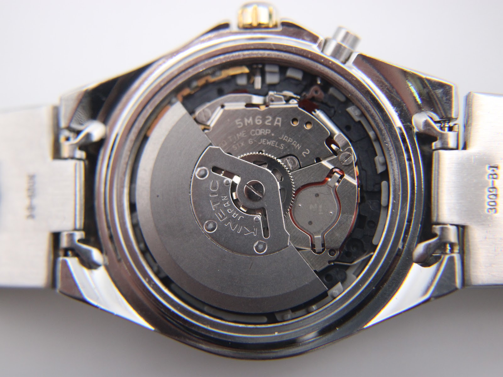 Close-up of the Seiko 5M62A Kinetic movement inside the watch, showing the rotor and internal components.