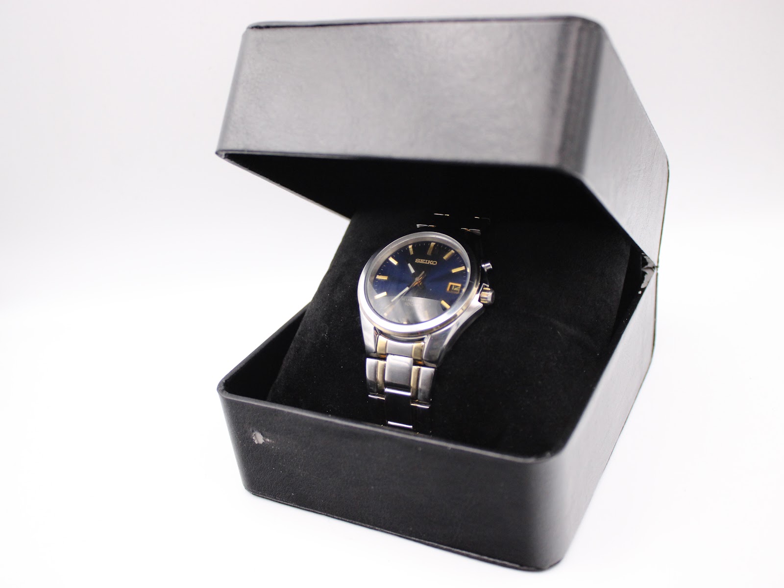 The Seiko watch nestled in a black presentation box.