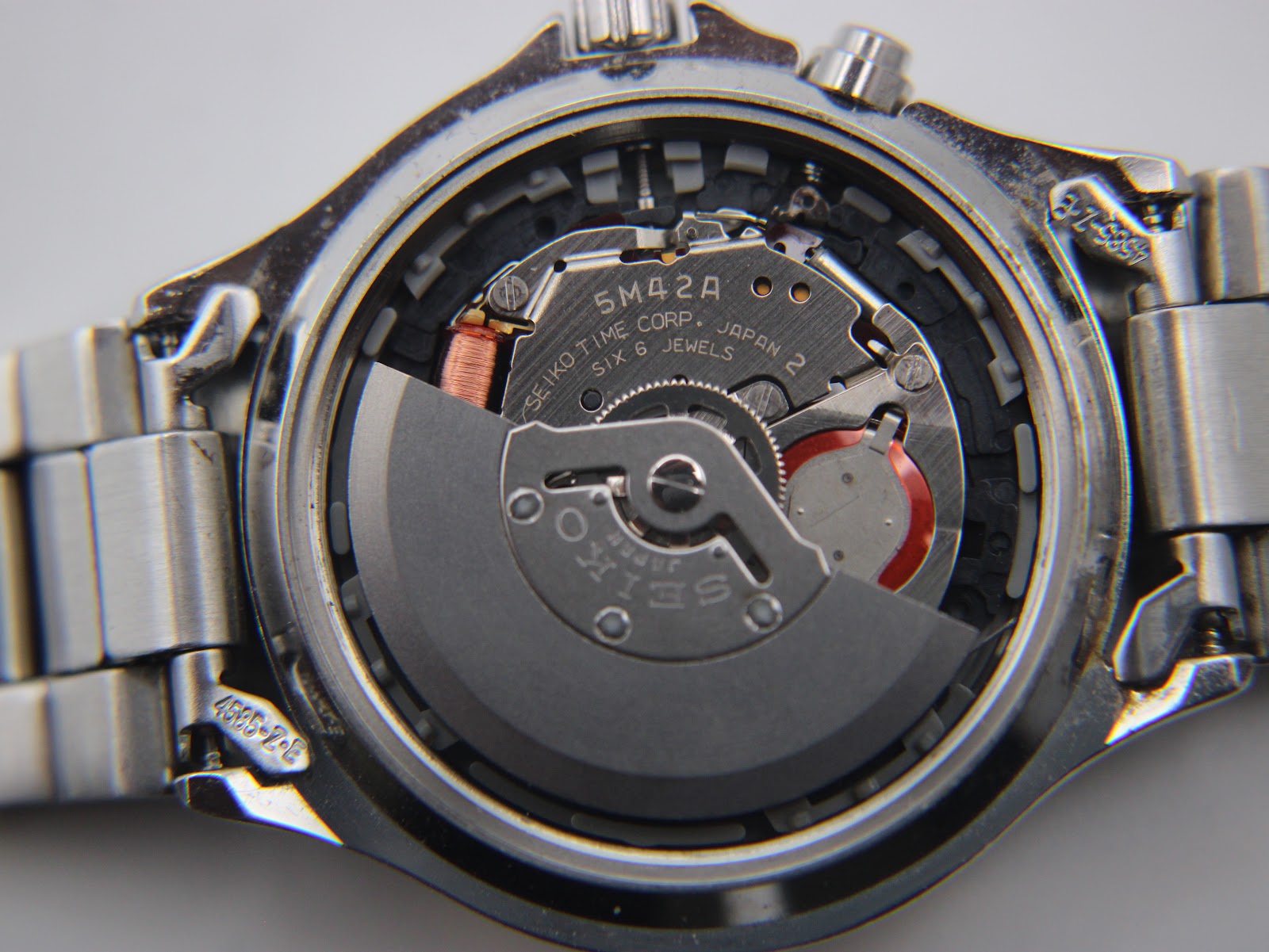 Close-up of Seiko 5M42A Kinetic movement inside the watch case.