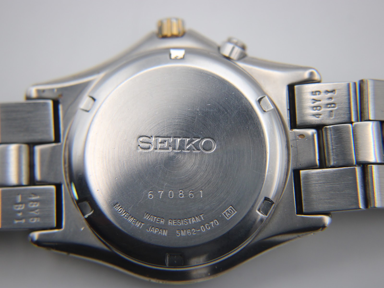 Close-up of the polished stainless steel case back, engraved with 'SEIKO', serial number '670861', 'WATER RESISTANT', 'MOVEMENT JAPAN', and '5M62-0C70'.