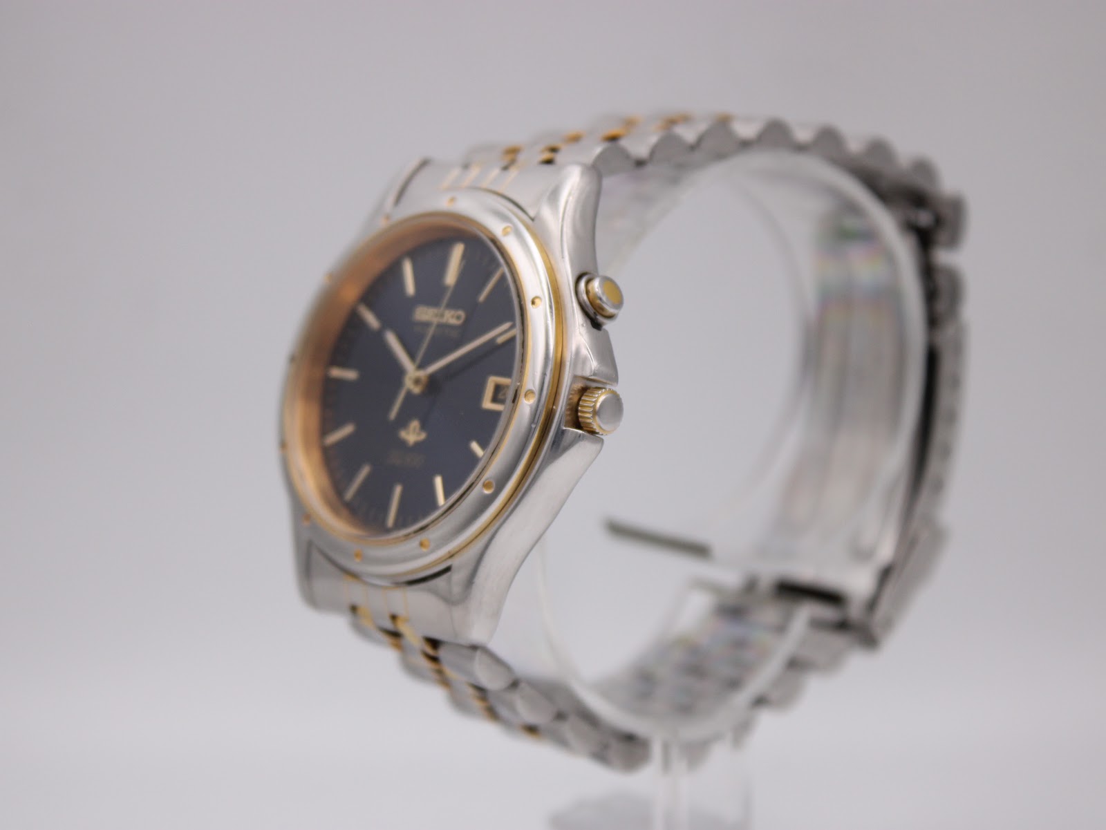 Angled side view of the Seiko Kinetic watch showing the gold-tone crown and push button.