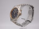 Angled side view of the Seiko Kinetic watch showing the gold-tone crown and push button.