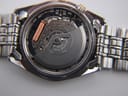 Detailed shot of the Seiko 5M42A kinetic movement inside the open case back, showing 'SEIKO TIME CORP. JAPAN SIX 6 JEWELS'.