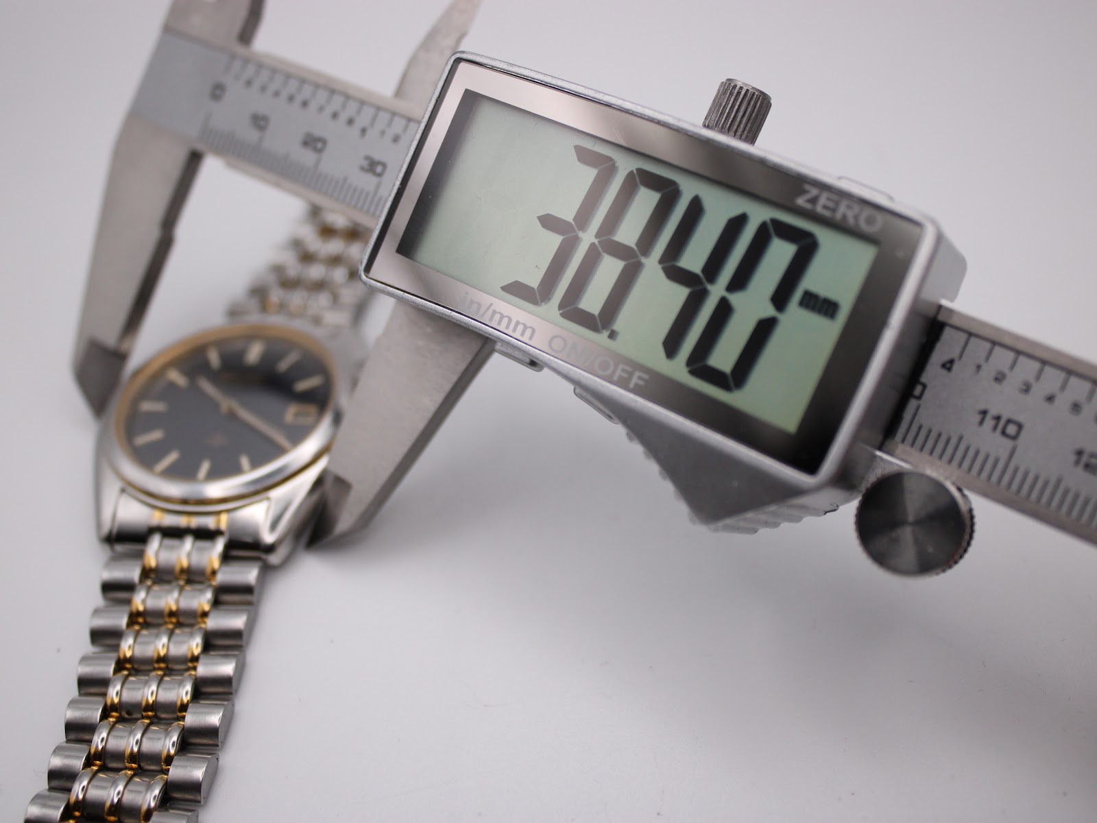 Digital caliper measuring the case diameter of the Seiko watch at 38.40mm.
