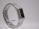 Angled front-left view of the Seiko watch on a display stand, highlighting the integrated bracelet design.