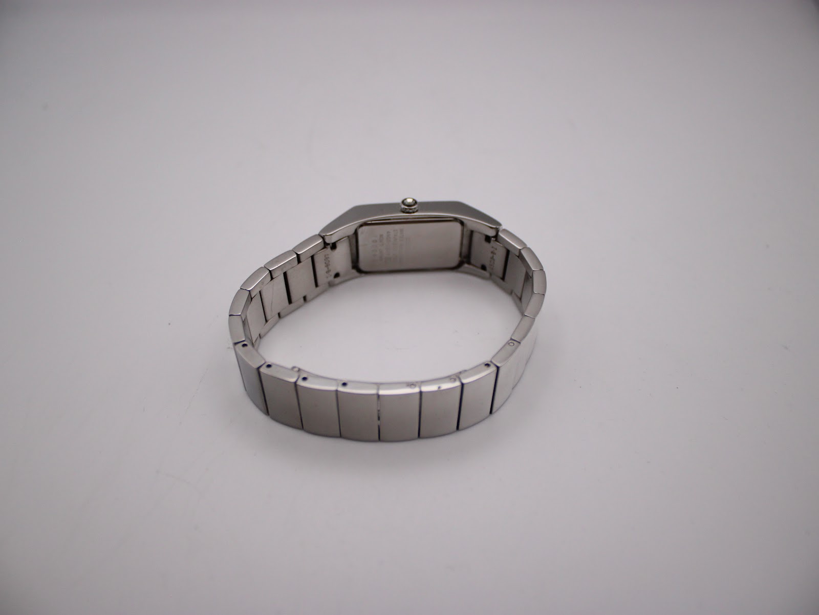 Rear view of the watch showing the integrated stainless steel bracelet with the deployant clasp closed.