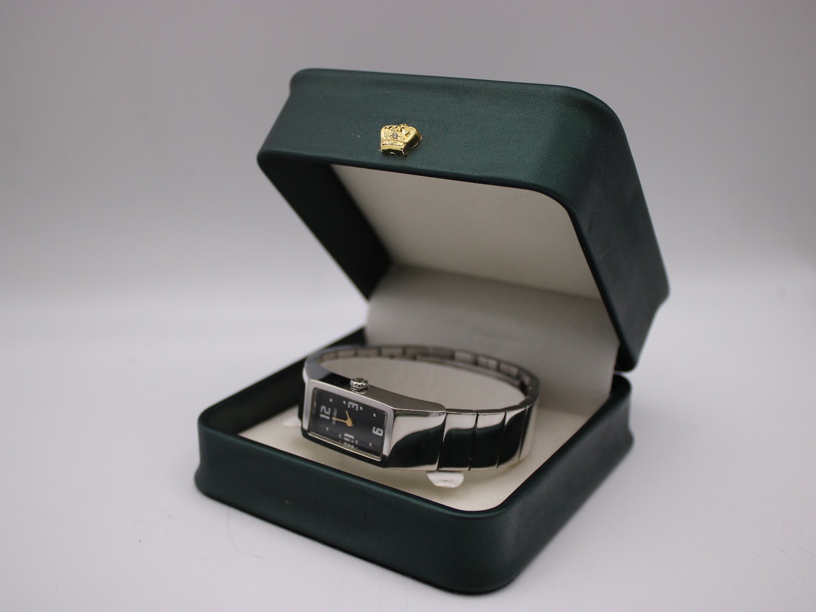 The Seiko watch displayed within a dark green presentation box with a gold crown emblem.