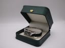 The Seiko watch displayed within a dark green presentation box with a gold crown emblem.