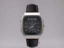 Front view of the Seiko H556-5030 ana-digi watch with square silver case and black leather strap.