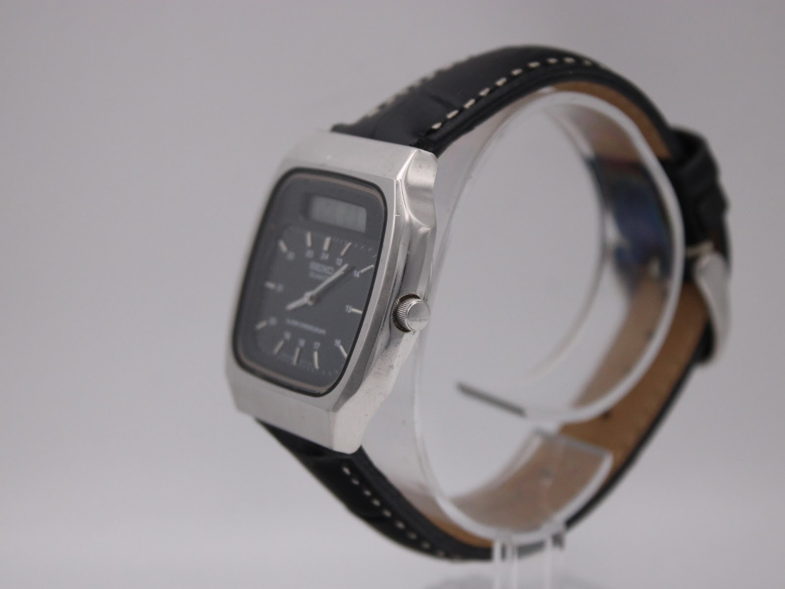 Angled right-side view of the Seiko H556-5030 watch, showing crown and case profile on a stand.