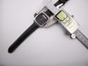 Overhead view of the Seiko H556-5030 watch case being measured by a digital caliper, displaying 33.47mm.