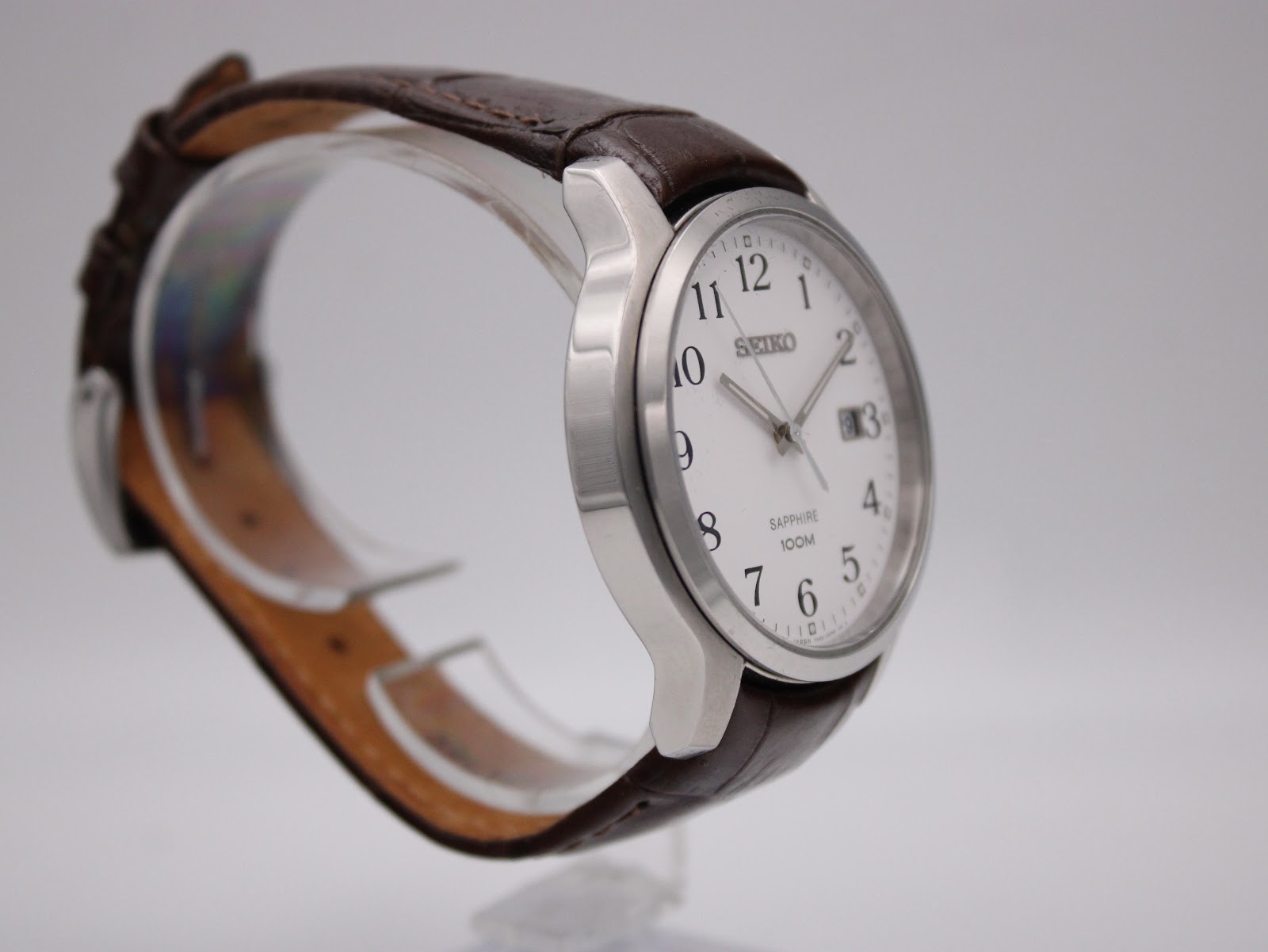 Angled side view of the Seiko watch, highlighting the case profile and the texture of the brown leather strap.
