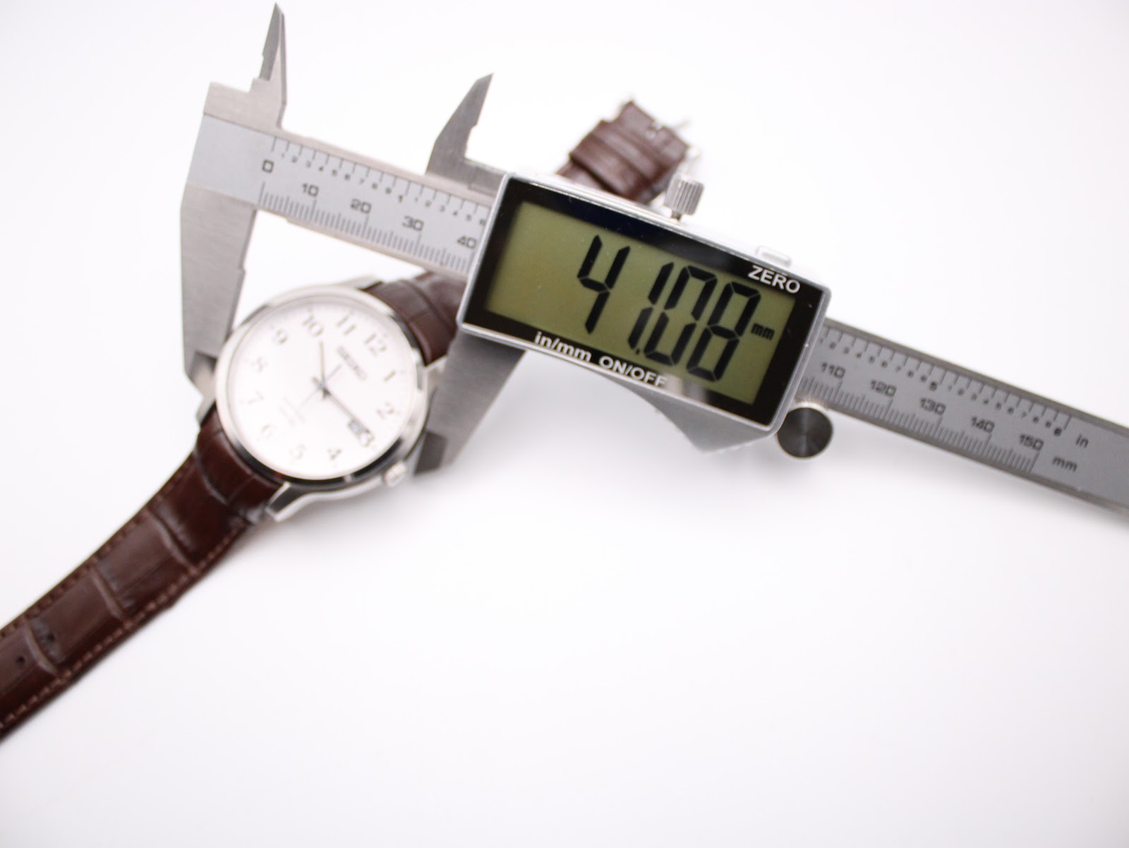 Digital caliper measuring the watch case diameter at 41.08mm, with the Seiko watch visible in the background.
