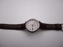 Top-down view of the Seiko watch with its brown leather strap laid flat, showcasing the dial and strap length.
