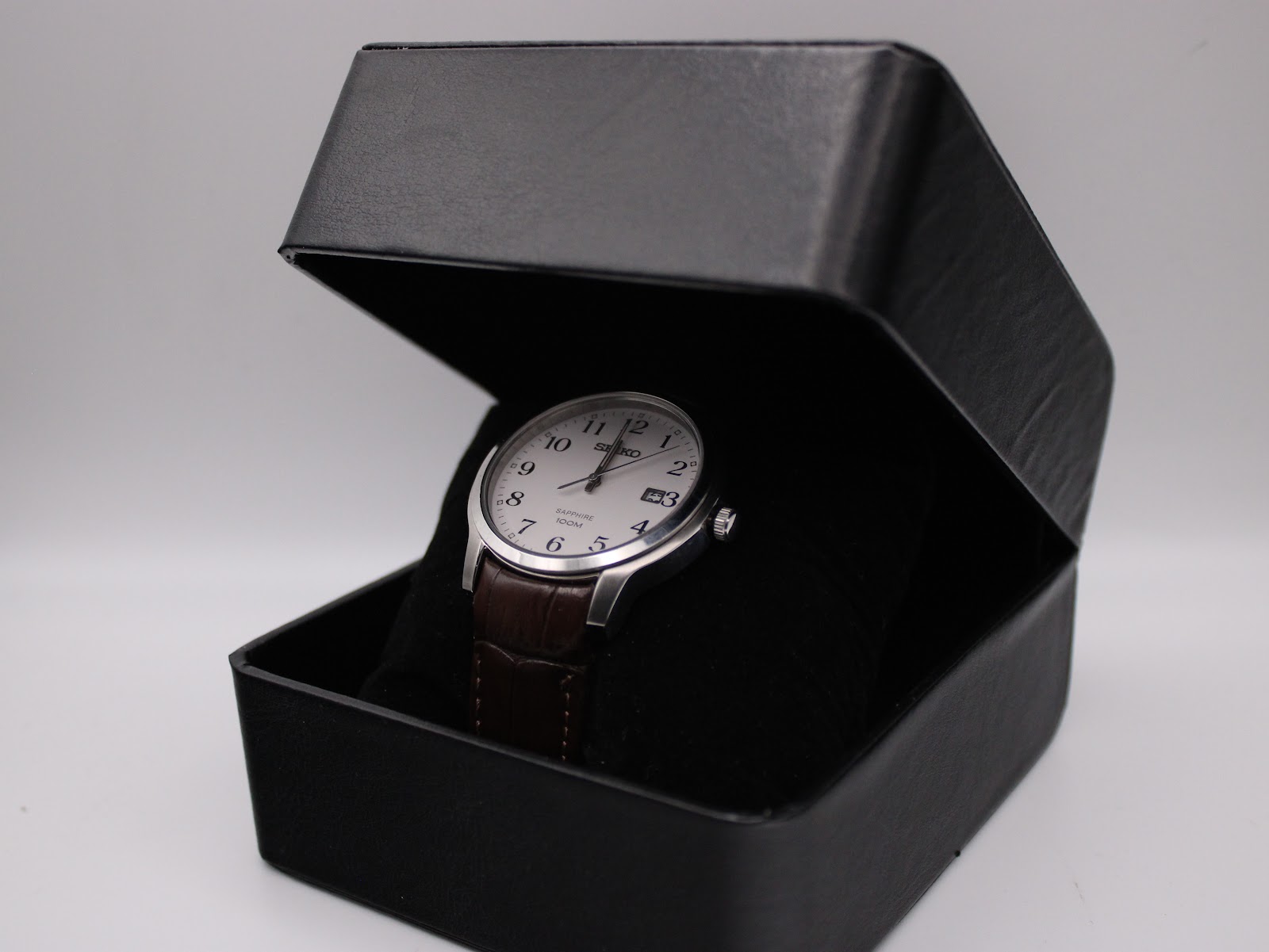 The Seiko watch nestled inside a generic black presentation box.