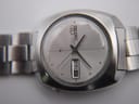Close-up of the vintage Seiko's silver sunburst dial, displaying applied indices, hands, and the day-date window.
