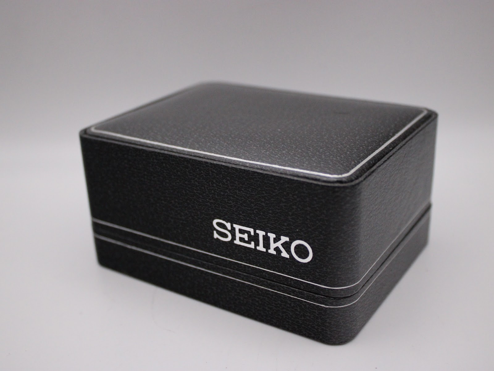 The closed original black Seiko presentation box with "SEIKO" branding on the lid.