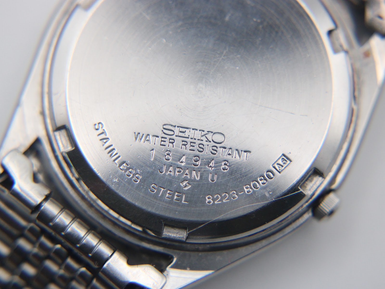Close-up of the Seiko 8223-8080 stainless steel case back with serial number, "water resistant", and model designation.