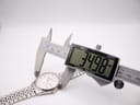 Digital caliper measuring the case diameter of the Seiko watch, displaying a precise measurement of 34.98mm