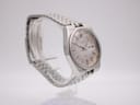 Angled left side view of the vintage SEIKO watch on a clear display stand, showing the crown and integrated bracelet.
