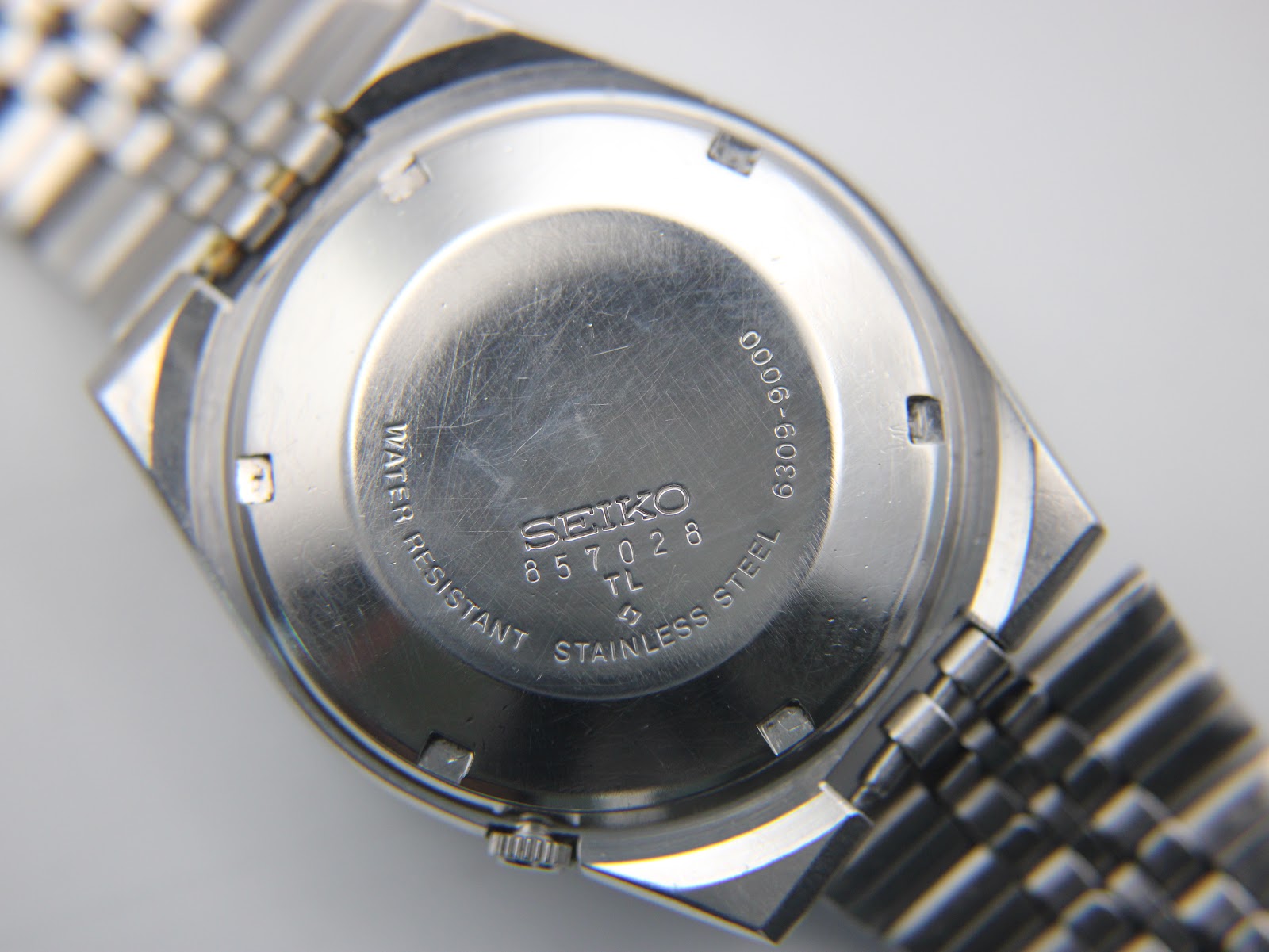 Close-up of the stainless steel case back of the SEIKO 6309-9000, showing serial number 857028 and model information.