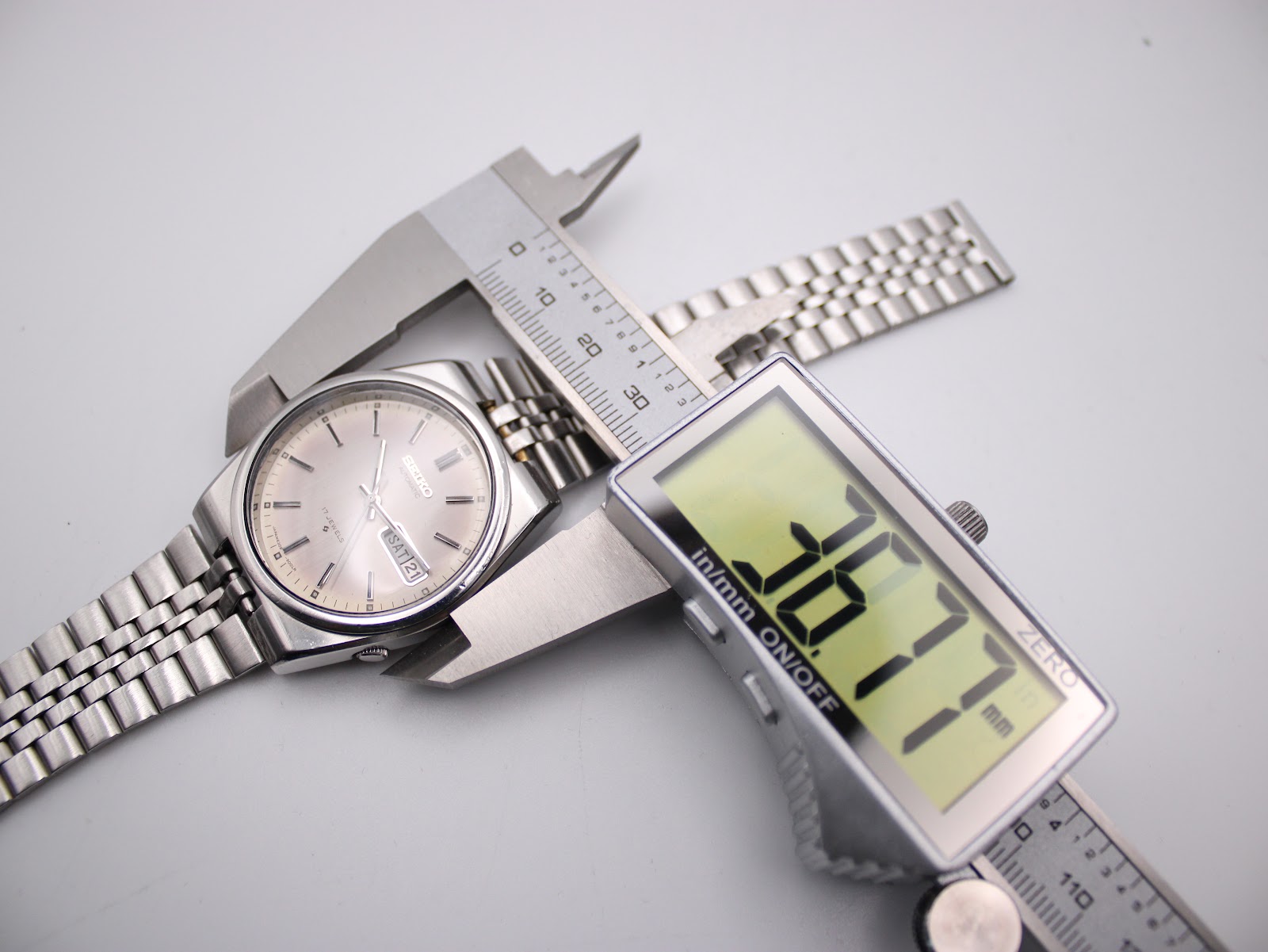 Digital caliper measuring the SEIKO watch case diameter, displaying 36.77mm.