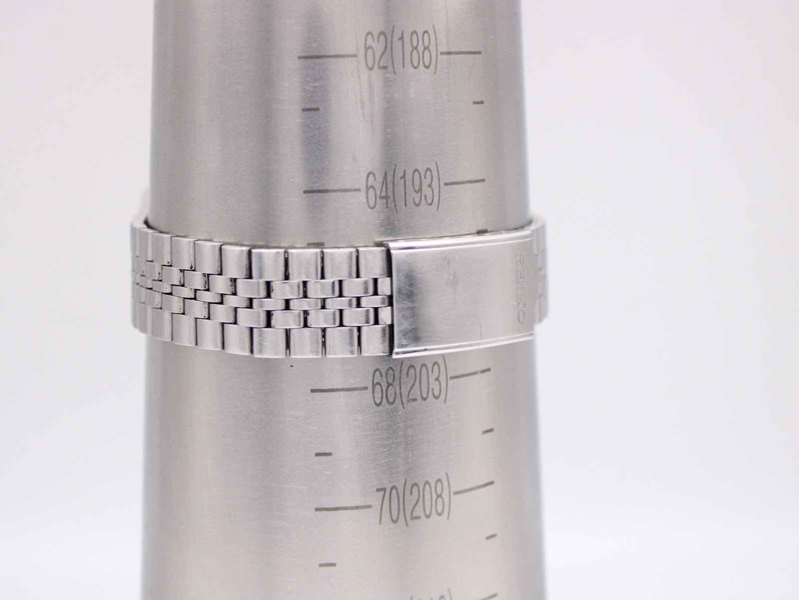 Close-up of the jubilee-style stainless steel bracelet on a wrist sizing gauge, showing an approximate wrist size of 19.8cm.