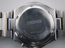 Close-up of the stainless steel case back, showing the serial number 323233 and "WATER RESISTANT 10 BAR".