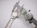 Digital caliper measuring the case diameter of the Seiko watch, displaying a precise measurement of 38.14mm.