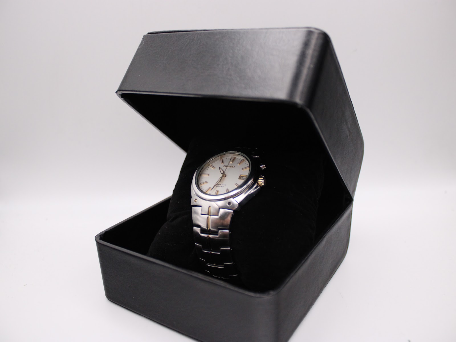 The Seiko 5M62-0AK0 watch nestled inside its open, original black Seiko box.