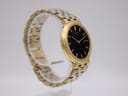 Angled side profile of the gold-tone Seiko 7N29-7A00 watch on a display stand.