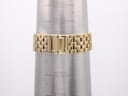 Close-up of the integrated gold-tone bracelet on a wrist sizing gauge, showing a wrist size of approximately 16.5cm.