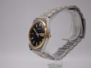 Angled view of the Seiko V743-9020 vintage quartz watch on a display stand, showing the right side and gold crown.