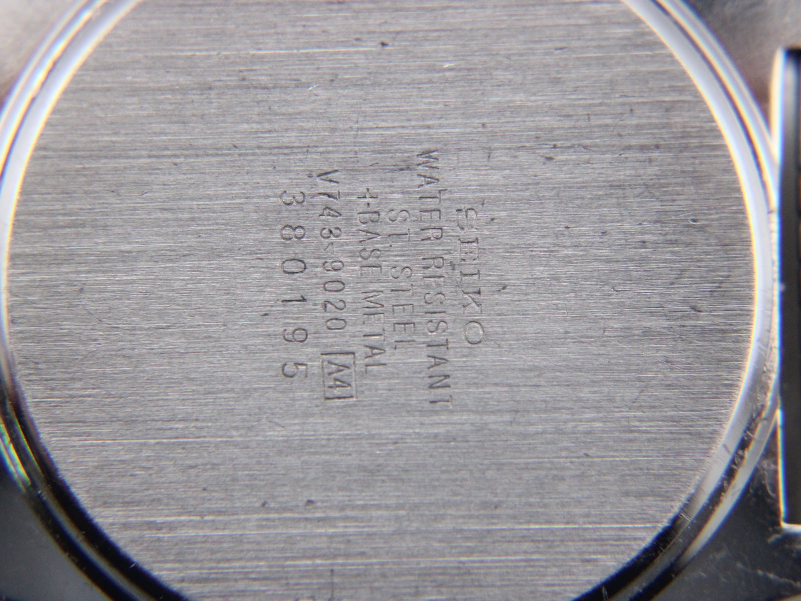 Close-up of the brushed stainless steel caseback engraved with Seiko, 'V743-9020', and serial number '380195'.