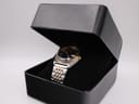 The Seiko V743-9020 two-tone watch nestled in a black velvet interior inside a black presentation box.