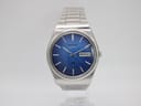 Front view of the Seiko 7546-8200 watch, showcasing its navy blue sunburst dial and integrated stainless steel bracelet.