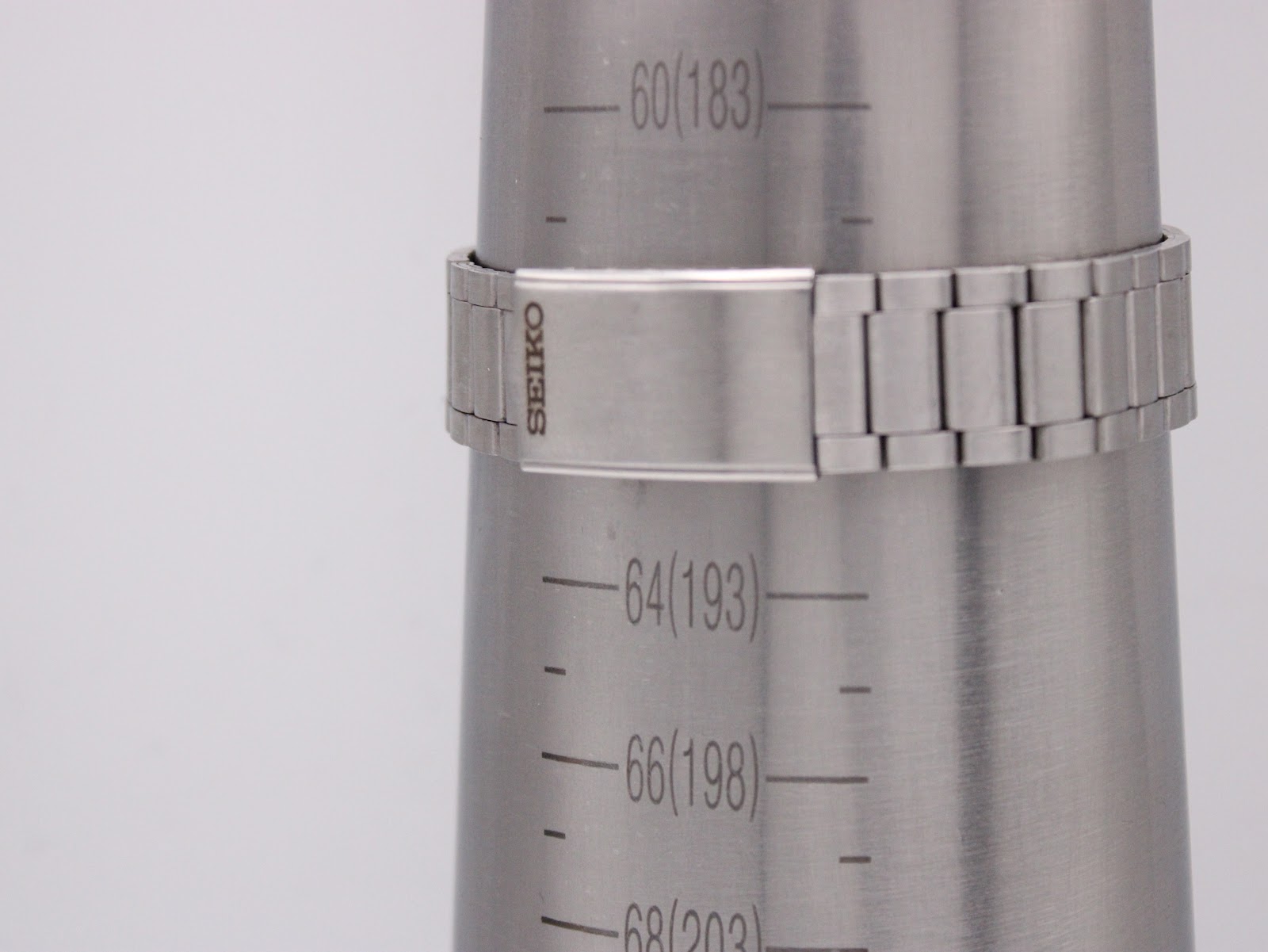 The Seiko integrated stainless steel bracelet with signed clasp on a wrist sizing cone, showing a wrist circumference of 188mm.