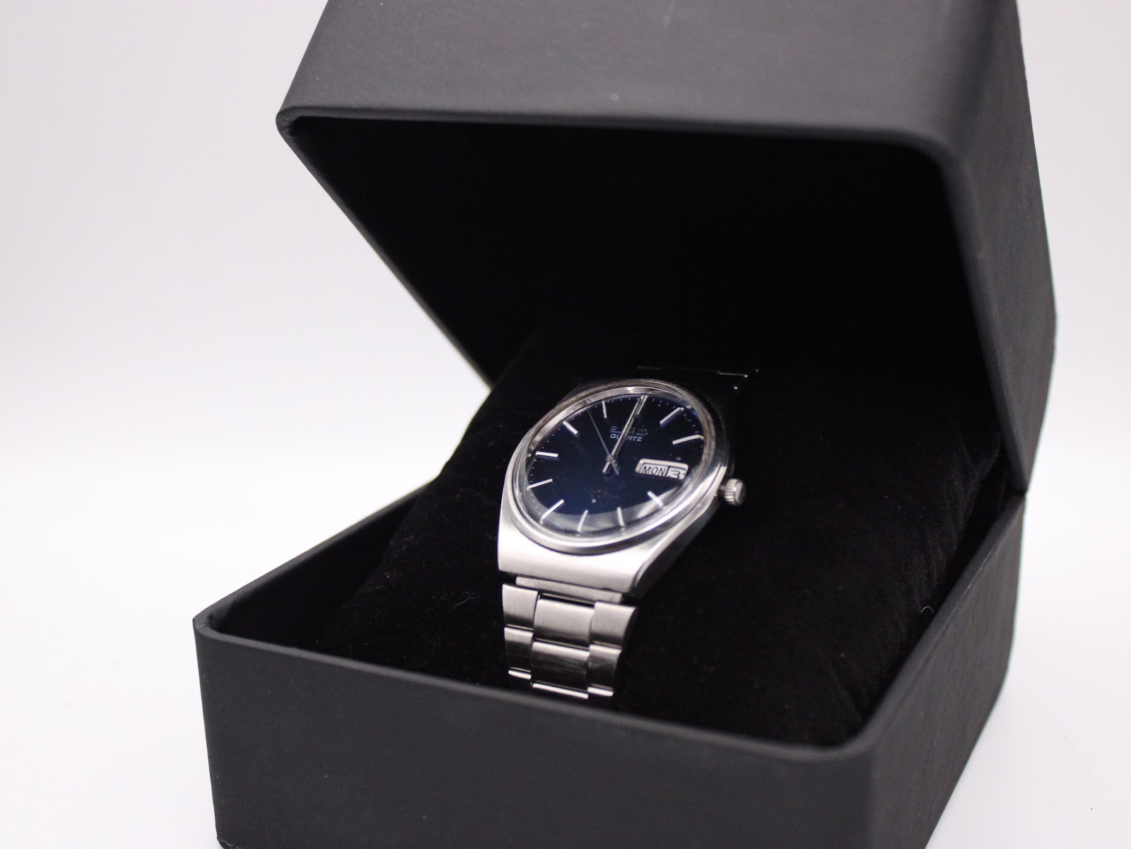 The Seiko 7546-8200 watch displayed inside an open black gift box with a velvet cushion.