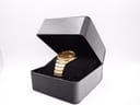 The Seiko gold-tone watch presented inside an open black rectangular watch box with a velvet cushion.