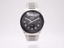Front face view of a vintage Seiko 8223-704B watch with a black dial, white Arabic numerals, day-date, and integrated stainless steel bracelet.