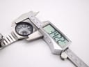 Digital caliper measuring the case diameter of the Seiko watch, displaying a precise measurement of 34.22mm.