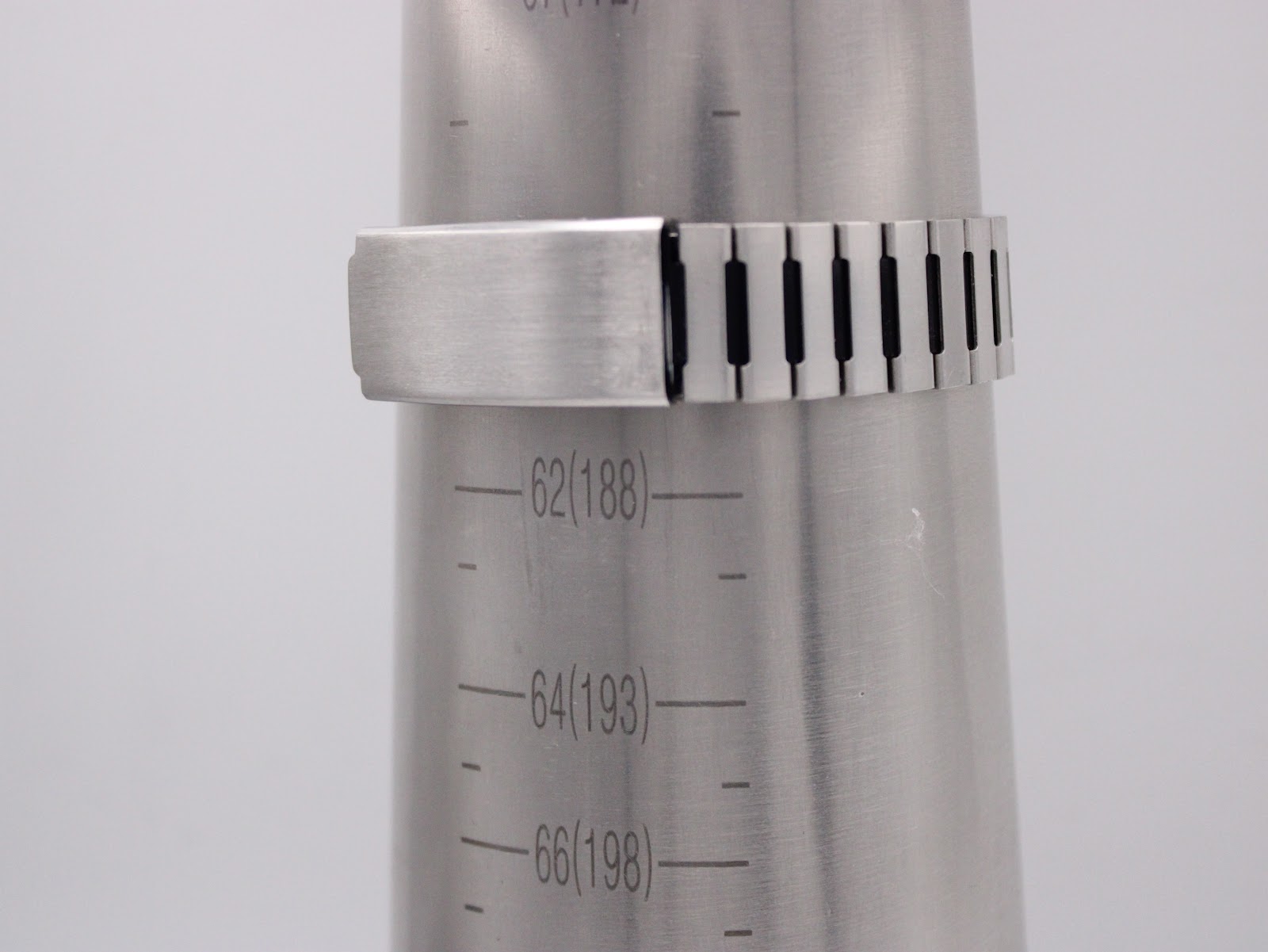 Integrated stainless steel bracelet wrapped around a wrist sizing gauge, indicating a maximum wrist fit of approximately 188mm / 18.8cm.