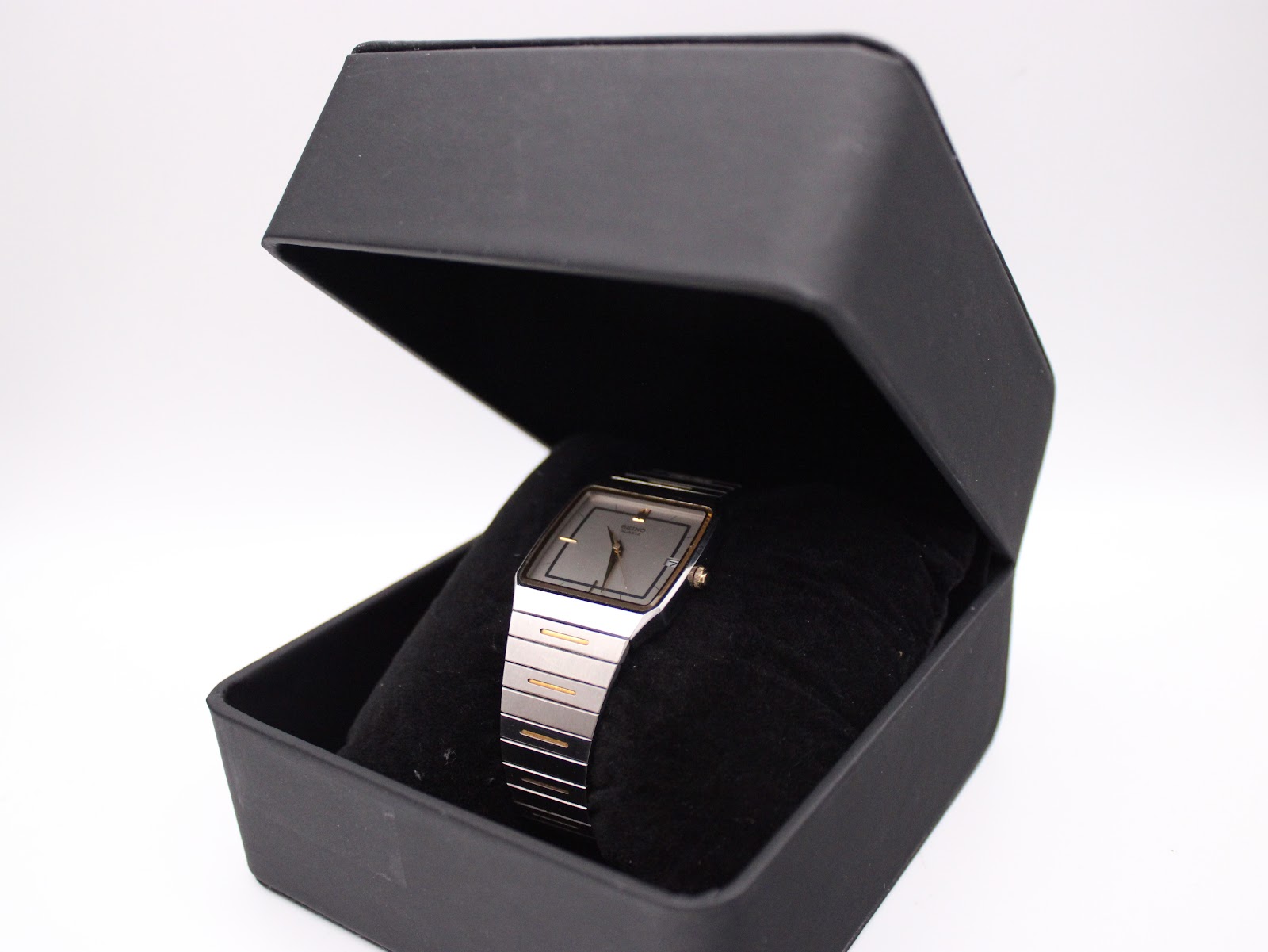 The Seiko two-tone watch presented in an open black display box with a velvet cushion.