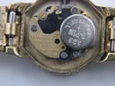 Macro shot of the quartz movement inside the watch, revealing the battery and 'SEIKO TIME CORP' markings.