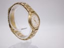 Another angled side view of the gold tone Seiko watch, showing the integrated bracelet design on a clear stand.