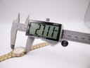 Digital caliper measuring the case diameter of the Seiko watch, displaying a precise measurement of 27.11mm.