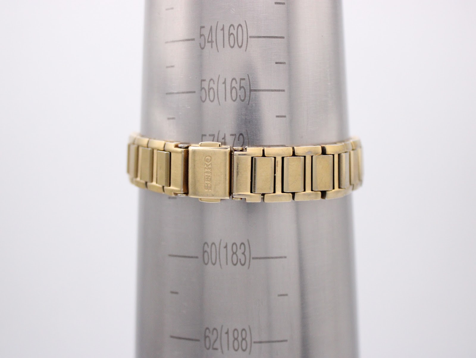 Gold tone Seiko bracelet on a wrist sizing mandrel, indicating a wrist circumference measurement of approximately 16.5cm.