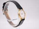 Another angled side view of the Seiko watch, showing the case profile and black leather strap on a stand.